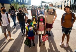 Students wait to enter the brand new John S. McCain III Elementary School on the first day of school in Buckeye, Ariz., on Aug. 4, 2021.