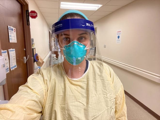 Melissa Schumacher, nurse manager of St. Elizabeth-Edgewood Pulmonary Unit, enters a COVID-19 patient's room on Thursday, Jan. 20, 2022. She works as a staff nurse as well as managing her staff because of nursing shortages - often caused by her staff getting COVID-19.