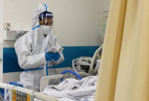 The son of a patient diagnosed with COVID-19 prays next to his father's hospital bed, in the coronavirus ward at Shaare Zedek Medical Center in Jerusalem, on January 20, 2022. (Olivier Fitoussi/Flash90)