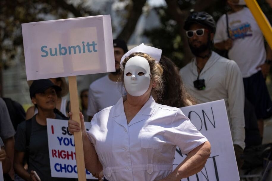 A protester dressed as a scary nurse holds a mispelled sign that reads "Submitt" at an anti-vaccination protest rally near City Hall, following the Los Angeles City Council's vote earlier this week on drafting an ordinance requiring proof of vaccination to enter many indoor public spaces in Los Angeles, on August 14, 2021. (Photo by DAVID MCNEW / AFP) (Photo by DAVID MCNEW/AFP via Getty Images)
