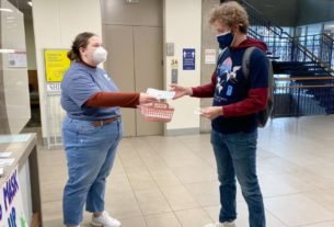 Anna+Ardelean%2C+Student+Government+Association+president%2C+hands+a+KN95+mask+and+COVID-19+information+to+Christian+Holman%2C+a+senior+sociology+major%2C+Thursday+in+the+University+Center+West.+SGA+has+been+distributing+COVID-19+masks+in+University+Center+West+Wednesday+and+Thursday.++