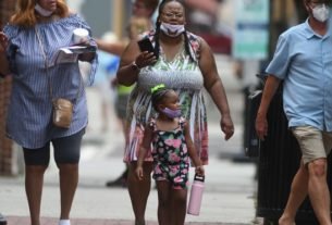 People wear masks while walking along Front St. in downtown Wilmington, N.C., Wednesday, July 15, 2020.